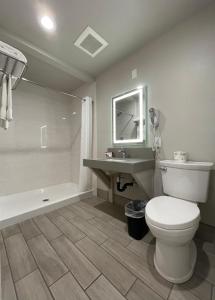 尤金Budget Lodge Eugene - Airport的浴室配有卫生间、盥洗盆和浴缸。
