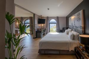 里斯本138 Liberdade Hotel的卧室配有一张白色大床和一张书桌
