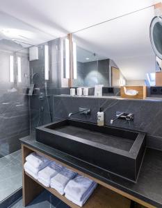 加尔米施-帕滕基兴Hotel Staudacherhof History & Lifestyle的一间带黑色浴缸和镜子的浴室