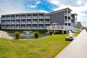 钦科蒂格Comfort Suites Chincoteague Island Bayfront Resort的一座大建筑,前面有一个池塘