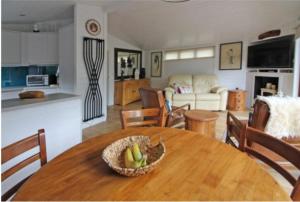 EardingtonAstbury Falls Luxury Retreats的厨房以及带木桌和一碗水果的客厅。