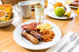 诺里奇快捷假日诺威奇酒店的包括香肠鸡蛋培根和水果的早餐食品