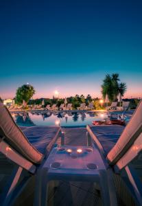 卡沃斯埃罗菲里酒店的享有带2把椅子和1张桌子的游泳池的景致。