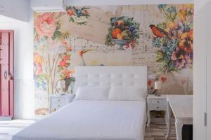 拉斯纳瓦斯德尔马尔克斯Casa Jardín El Colmenar的卧室配有白色的床和花卉壁纸
