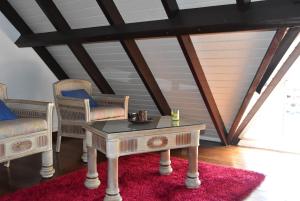 圣弗朗索瓦Maison Saphir的红色地毯上的房间,配有两把椅子和一张桌子