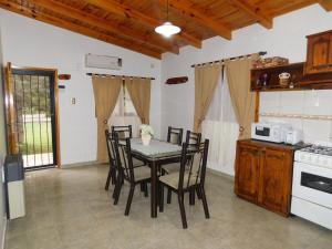 门多萨Cabañas Mirmar Mendoza的厨房里设有1间带桌椅的用餐室
