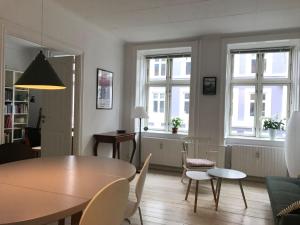 哥本哈根ApartmentInCopenhagen Apartment 1183的客厅配有桌椅和窗户。