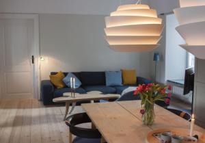 哥本哈根哥本哈根1185号公寓的客厅配有蓝色的沙发和桌子