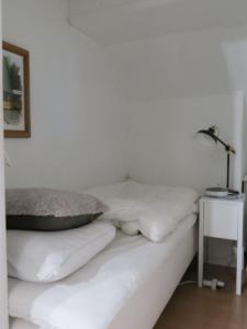 哥本哈根ApartmentInCopenhagen Apartment 1316的白色的床、白色枕头和灯