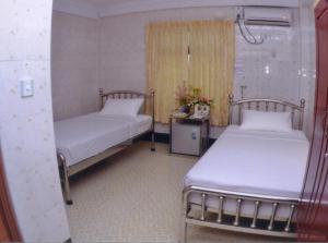 仰光秀烟陶酒店的一间设有两张床和一张鲜花桌的房间