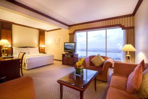 阿布扎比阿布扎比海滨大道酒店的酒店客房配有一张特大号床和一间客厅。