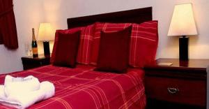 克鲁韦富丽酒店的一间卧室配有红色的床、红色床单和枕头