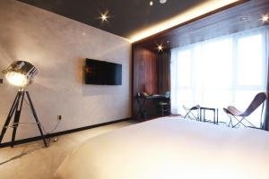 釜山拉昂酒店的一间卧室配有床、电视和摄像头