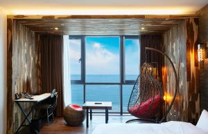 釜山拉昂酒店的卧室配有吊床,位于大窗户前