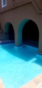 德班African Sun lodge的大楼内的一个蓝色海水游泳池