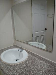 清迈โรงแรมไดมอนด์แกรนด์ เฮ้าส์ แอนด์ รีสอร์ท的浴室水槽设有镜子和浴缸