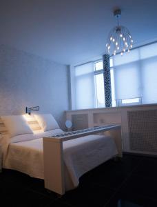 下诺夫哥罗德纳特维尔区公寓酒店的一间卧室配有一张床和一个吊灯