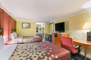 弗雷德里克Econo Lodge Frederick I-70的酒店客房设有两张床、一张桌子和一台电视。