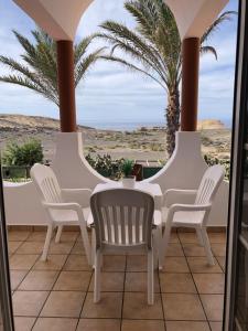 PájaraApartamento en La Pared Fuerteventura vista mar的一个带白色椅子的门廊,享有沙漠美景
