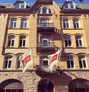 哈尔姆斯塔德诺瑞公园克拉丽奥连锁酒店的前面有两面旗帜的建筑