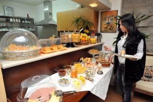 阿尔戈斯阿波罗酒店的自助餐中拿着一盘食物的女人