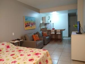 萨尔瓦多Farol da Barra 209的客房设有床、沙发和桌子。