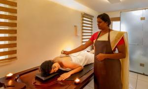 科钦Lhasa Ayurveda and Wellness Resort - A BluSalzz Collection, Kochi, Kerala的把头发梳在镜子里的女人