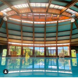 马拉卡韦罗Malalcahuello Thermal Hotel & Spa的一座带大型玻璃天花板的室内游泳池