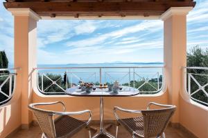 巴尔巴蒂Corfu Shell Apartments的窗户前的阳台配有桌椅