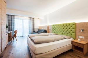 圣维吉利奥Piccolo Hotel Claudia No Pets的一间卧室配有一张大床和绿色床头板