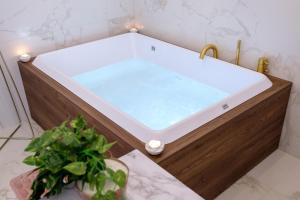 奥斯图尼La Bella Ostuni Suites的浴室设有热水浴缸,浴室内提供浴缸。