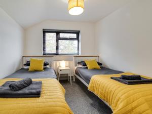 班戈2 Ysgoldy的配有黄色床单的客房内的两张床