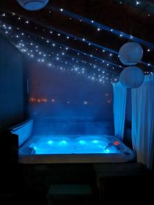 萨格勒布Apartment Viksa with Jacuzzi的灯火通明的房间的蓝色浴缸