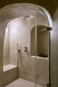 费拉Enigma Suites的浴室里设有玻璃门淋浴
