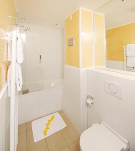 美因茨美因茨旅馆的白色的浴室设有卫生间和浴缸。
