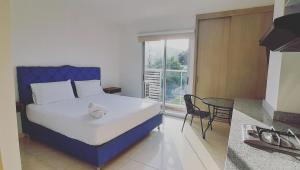 巴兰基亚Apartahotel Plaza de ángel 74的一间卧室配有一张床、一张桌子和一个窗户。