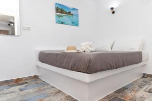 纳克索乔拉Depis Luxury Suites的一间白色卧室,卧室内配有一张床