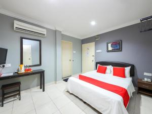 安邦Puteri Ampang Hotel的一间卧室配有一张带红色枕头的大床