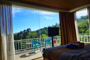 乌提La Niebla Farm Resort的一间卧室设有一张床,阳台设有大窗户