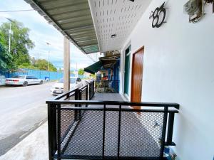 勿洞The 83 Betong GuestHouse的街边阳台设有黑色栏杆