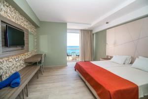 法里拉基Pegasos Deluxe Beach Hotel的配有一张床和一台平面电视的酒店客房