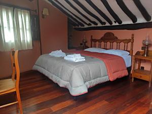 坎德拉里奥波萨达坎德拉里奥旅馆的一间卧室配有一张床,铺有木地板