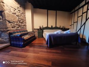 坎德拉里奥波萨达坎德拉里奥旅馆的一间卧室配有一张床、一张沙发和一把椅子