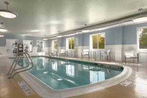 维斯塔宾厄姆顿大学假日酒店的大楼内带椅子的大型游泳池