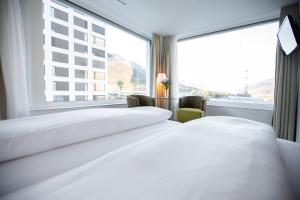 库尔Mercure Chur City West的配有大窗户的酒店客房内的两张床