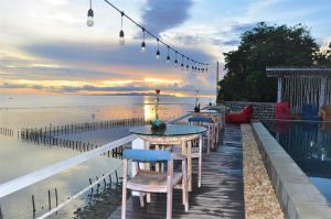 珀尼达岛Ocean Terrace Suite And Spa Luxury的海滩附近的码头上一排桌椅