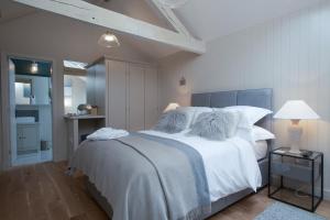 斯托昂泽沃尔德Stownes的卧室配有一张带白色床单和枕头的大床。