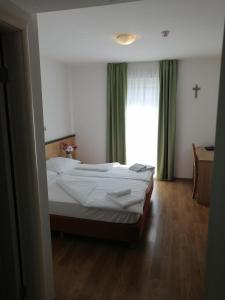 默主歌耶迪娜酒店的一间卧室设有一张床和一个窗口