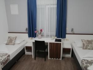 默主歌耶迪娜酒店的客房设有两张床、一张桌子和一张桌子。