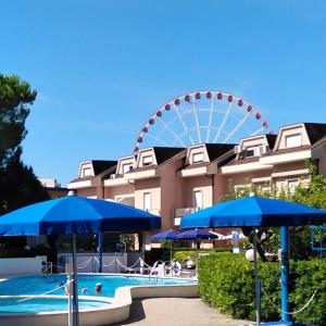 利多迪耶索罗B&C Apartments LA POSTA Home的摩天轮和带蓝伞的游泳池